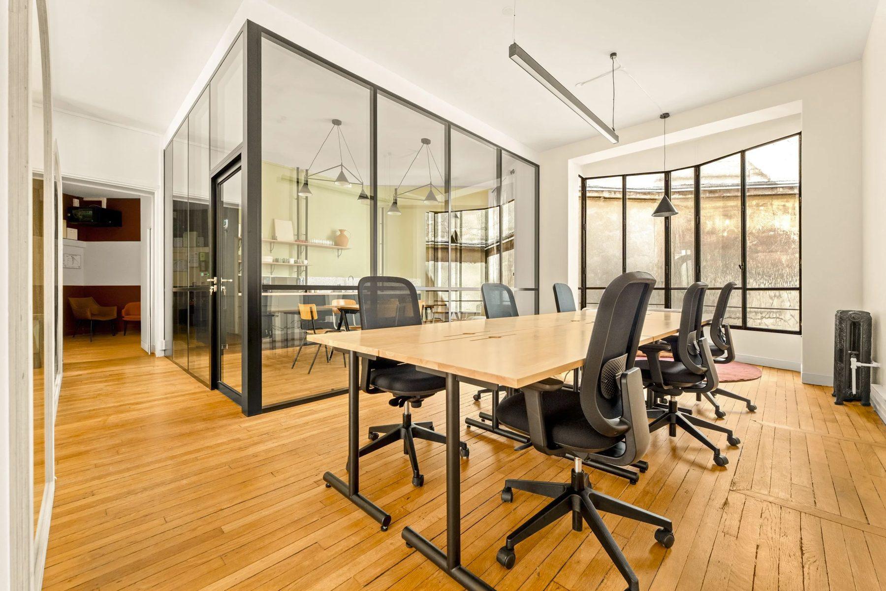 Pilea's Lille office: bright open workspace with a long wooden desk and a glass-walled meeting room